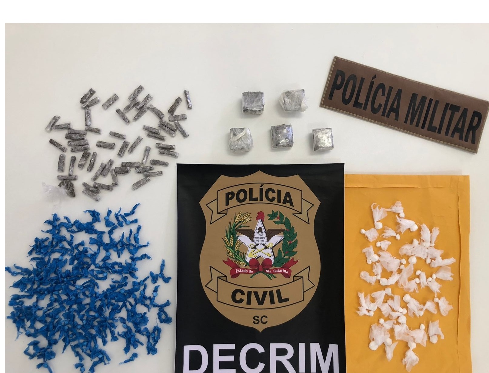 DROGAS E EMBLEMA DA POLICIA MILITAR E POLICIA CIVIL