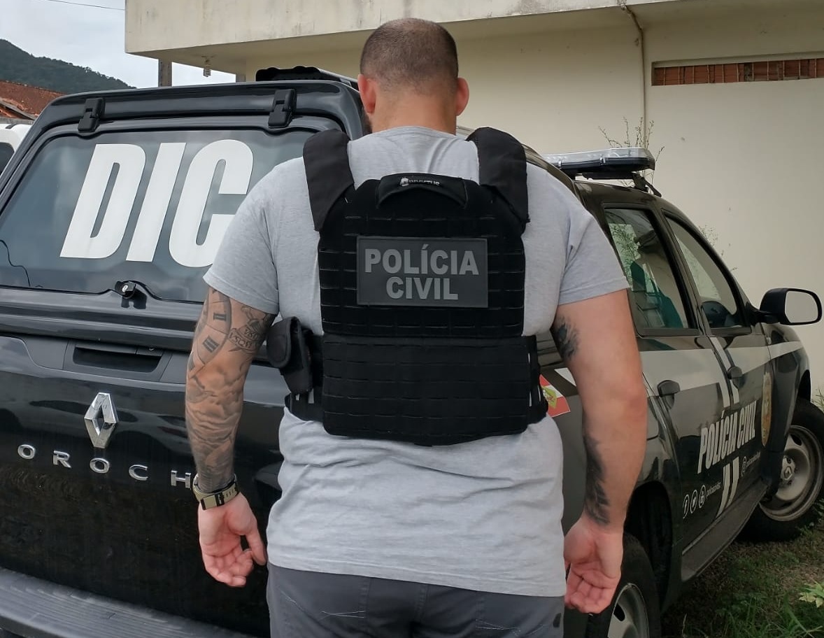 POLICIAL CIVIL EM FRENTE A UMA VIATURA DA POLICIA CIVIL