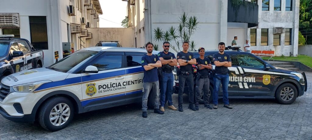viatura da policia cientifica e a frente dela policiais da policia cientifica e ao lado policiais civis em frente a viatura da policia civil