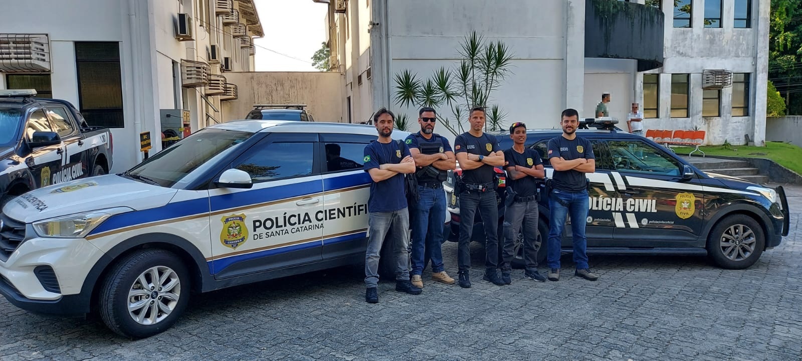 viatura da policia cientifica e a frente dela policiais da policia cientifica e ao lado policiais civis em frente a viatura da policia civil