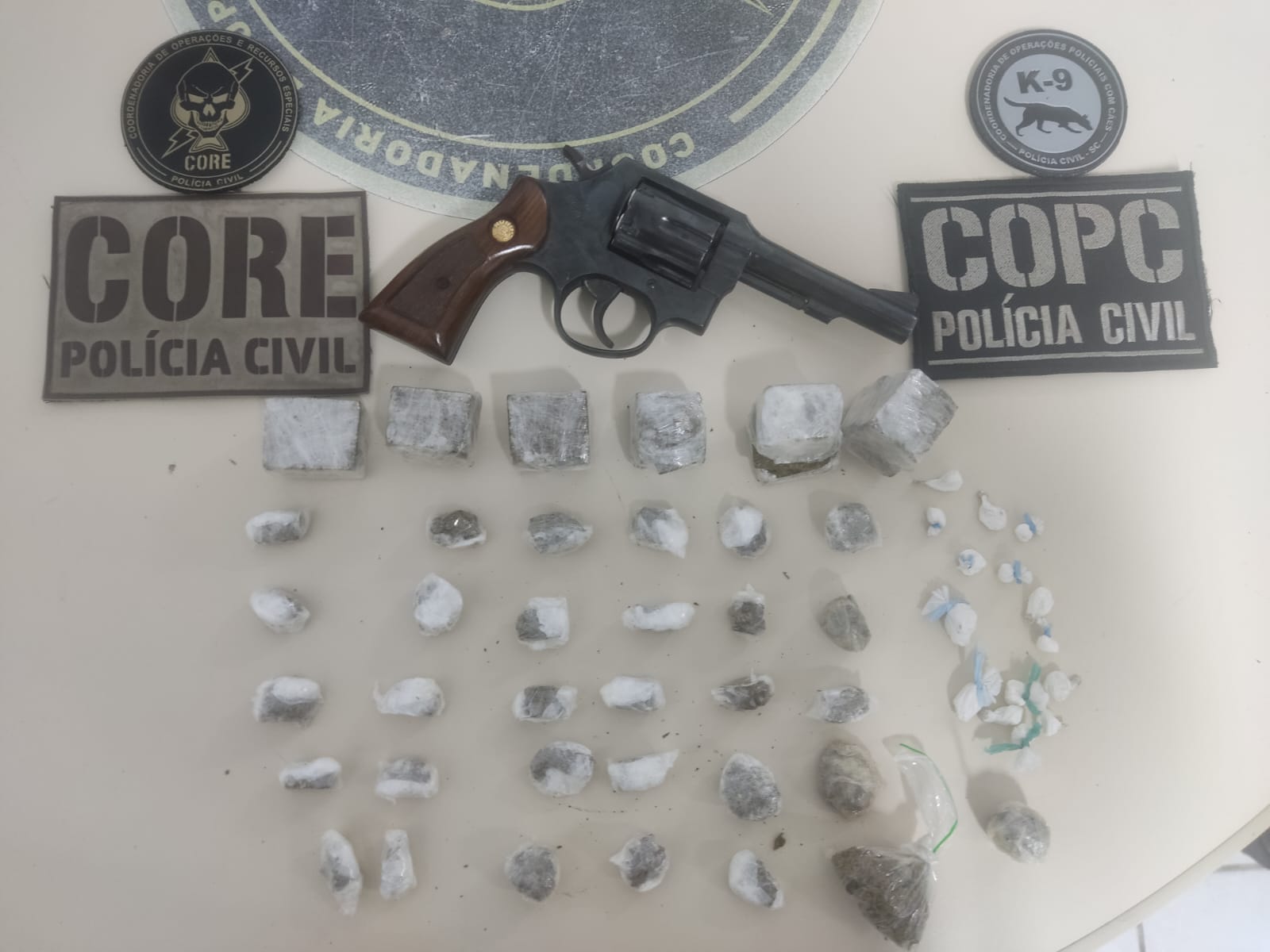 Drogas e arma apreendidas.