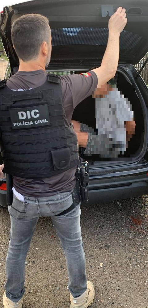 policial civil com porta mala aberto com detento den