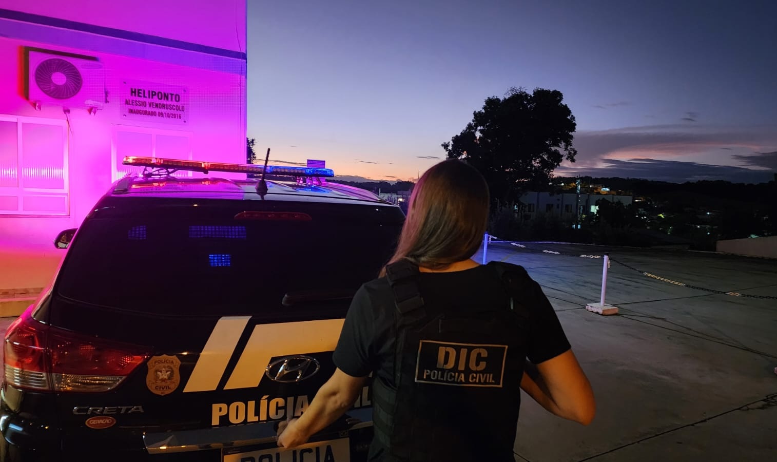 em frente ao heliporto uma viatura da policia civil e uma policial da DICem frente destas