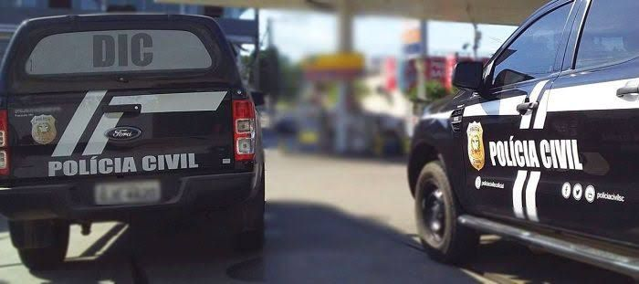 Duas viaturas em fundo um posto de gasolina