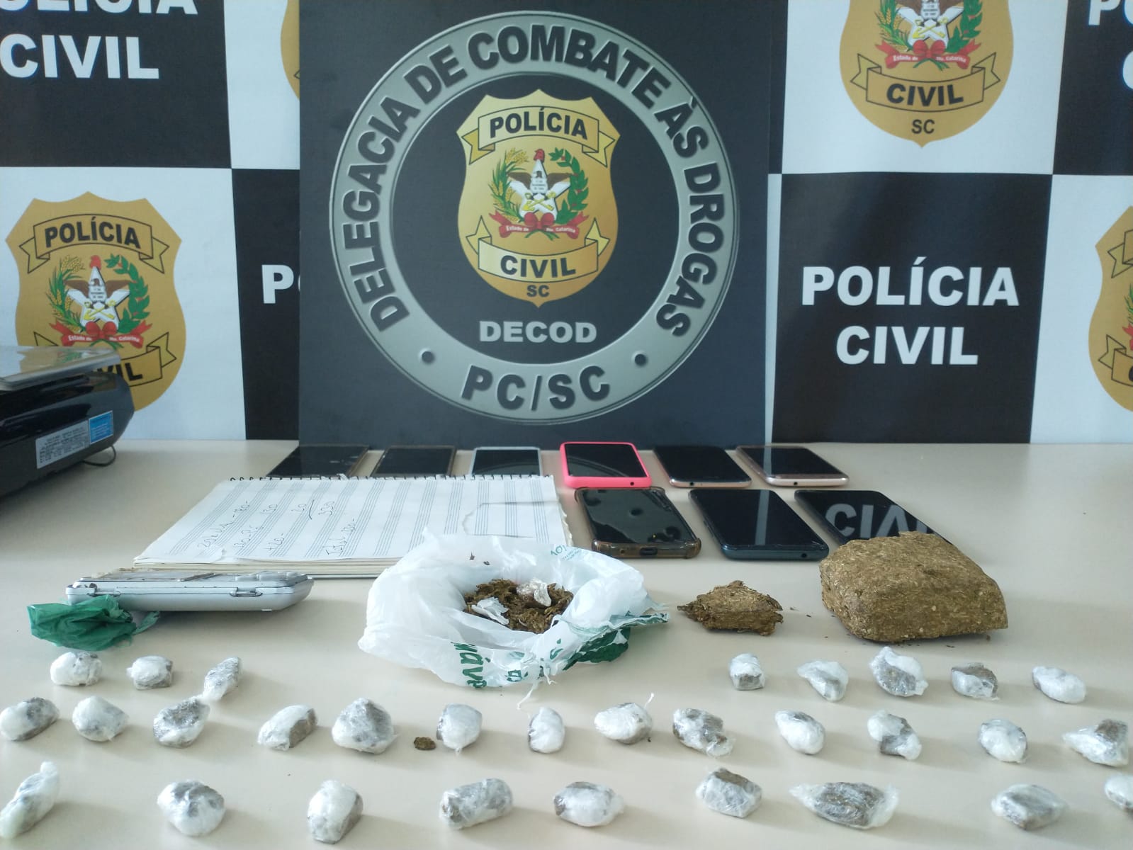 logo da Delegacia de Combate às Drogas, celular e drogas