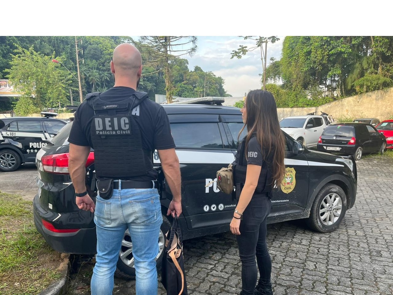 policiais da policia civil em frente da viatura de policia civil