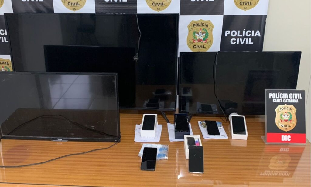 tres tvs, celulares e poster da DIC