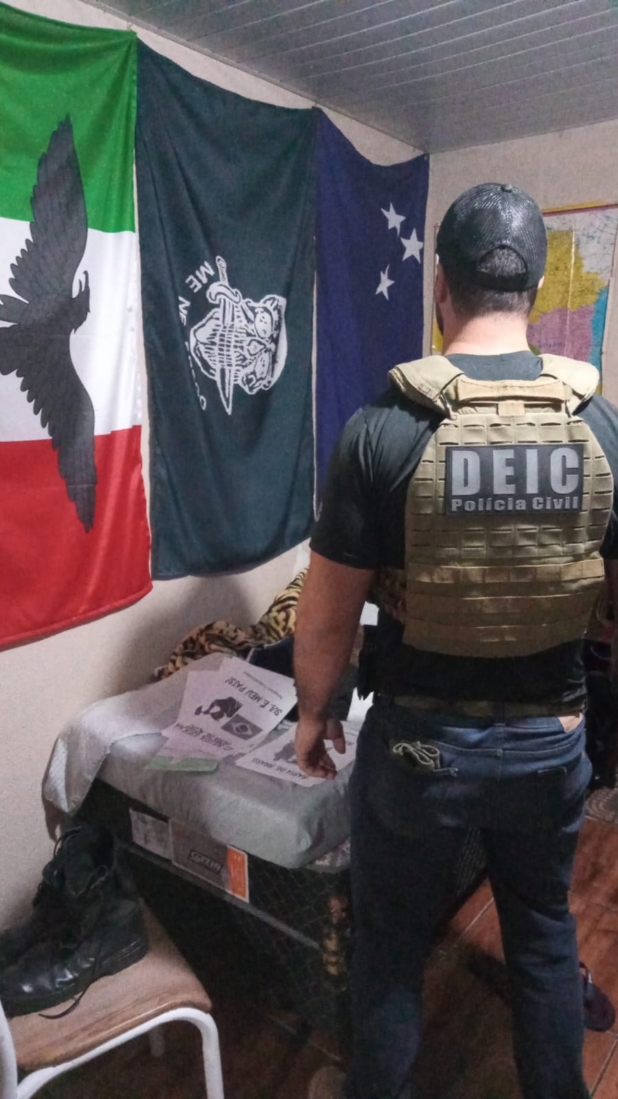 policial em frente a três bandeiras